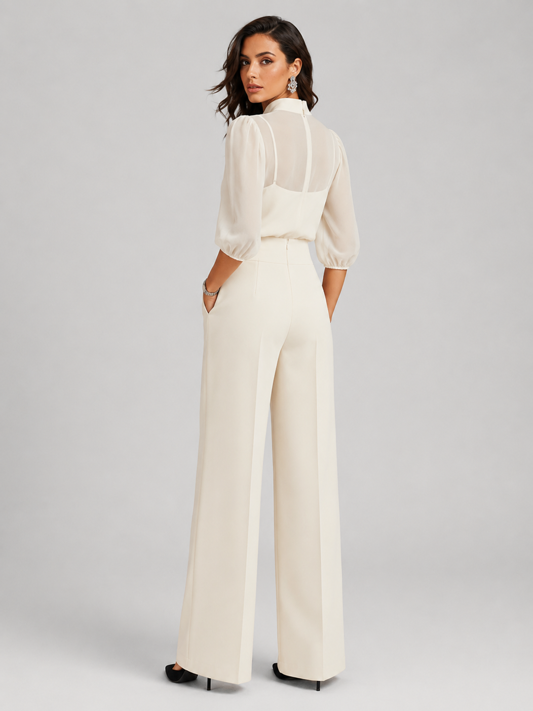 Femme portant un ensemble trois pièces avec blouse transparente et pantalon large, coloris blanc