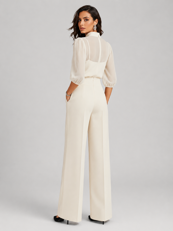 Femme portant un ensemble trois pièces avec blouse transparente et pantalon large, coloris blanc