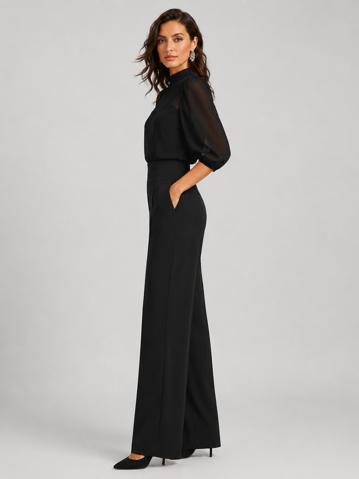 Femme portant un ensemble trois pièces avec blouse transparente et pantalon large, coloris noir