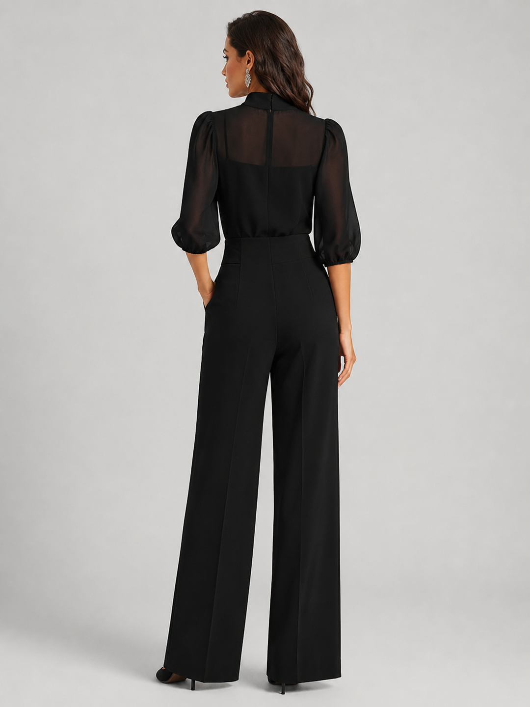Femme portant un ensemble trois pièces avec blouse transparente et pantalon large, coloris noir