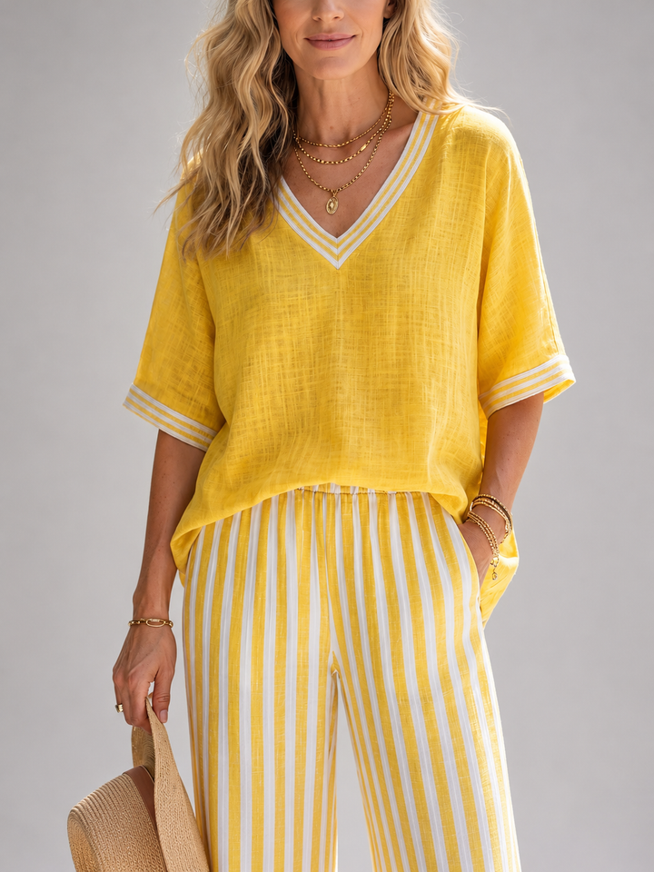 Femme portant un ensemble deux pièces avec tunique col V et pantalon large à rayures, coloris jaune
