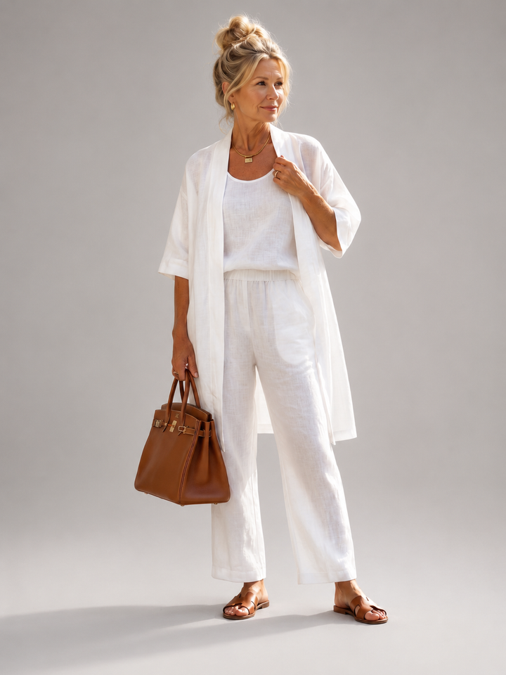 Femme portant un ensemble trois pièces avec haut, pantalon large et pièce ouverte assortie, coloris blanc
