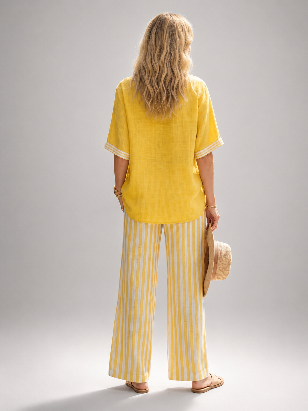 Femme portant un ensemble deux pièces avec tunique col V et pantalon large à rayures, coloris jaune