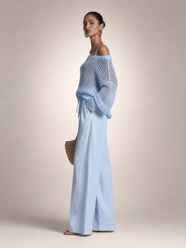 Femme portant un ensemble deux pièces avec haut en maille épaules dénudées et pantalon large, coloris bleu clair