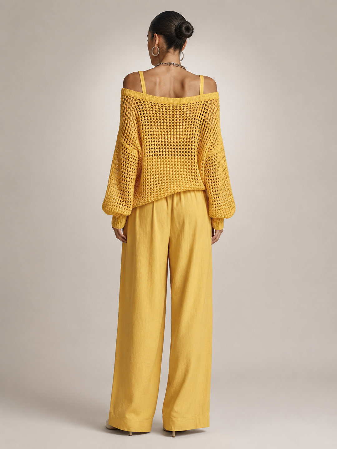Femme portant un ensemble deux pièces avec haut en maille épaules dénudées et pantalon large, coloris jaune