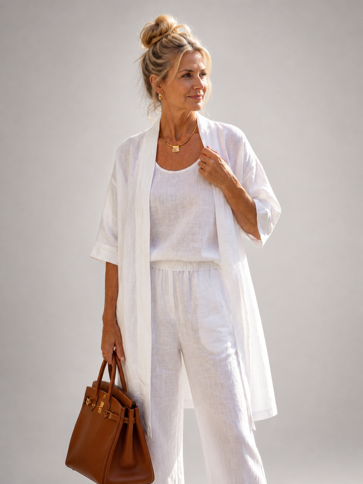 Femme portant un ensemble trois pièces avec haut, pantalon large et pièce ouverte assortie, coloris blanc