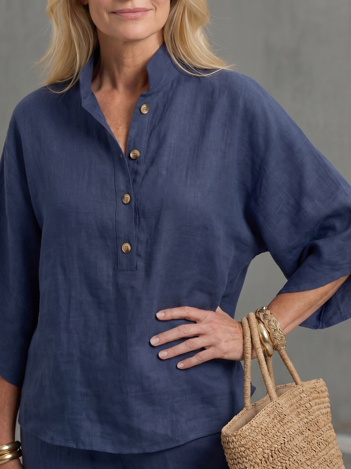 Femme portant un ensemble deux pièces avec tunique boutonnée et pantalon droit, coloris bleu marine