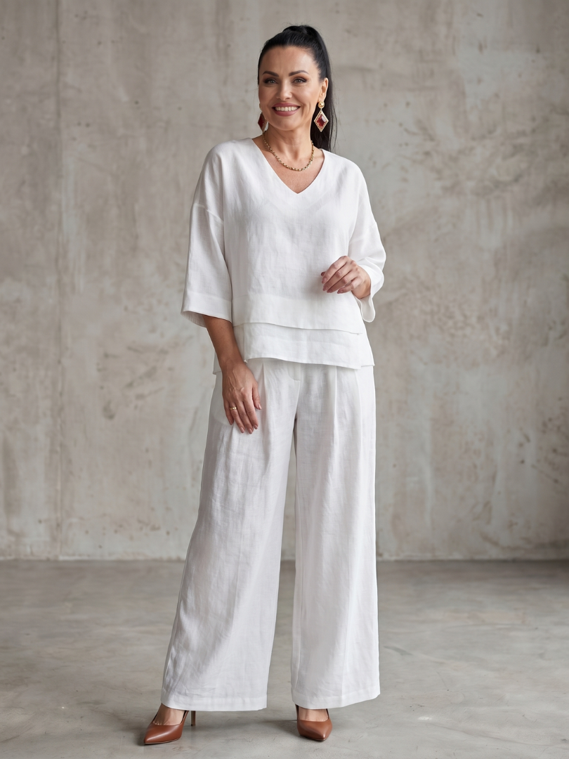 Femme portant un ensemble deux pièces avec haut superposé et pantalon à jambes larges, coloris blanc