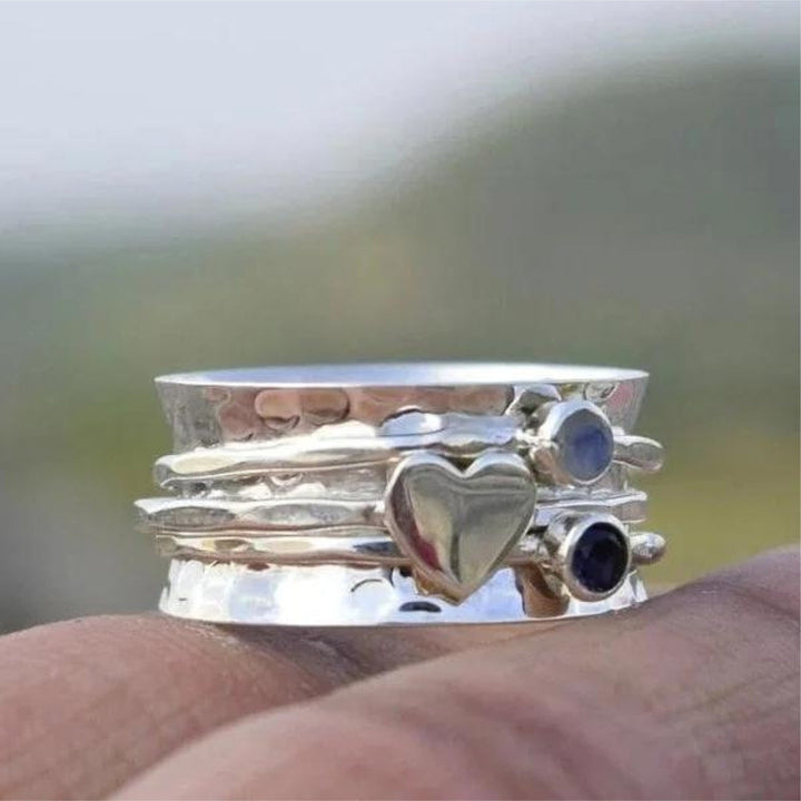 Cœur Pivotant | Bague tournante large argentée avec cœur et pierres bleues – Vue 01