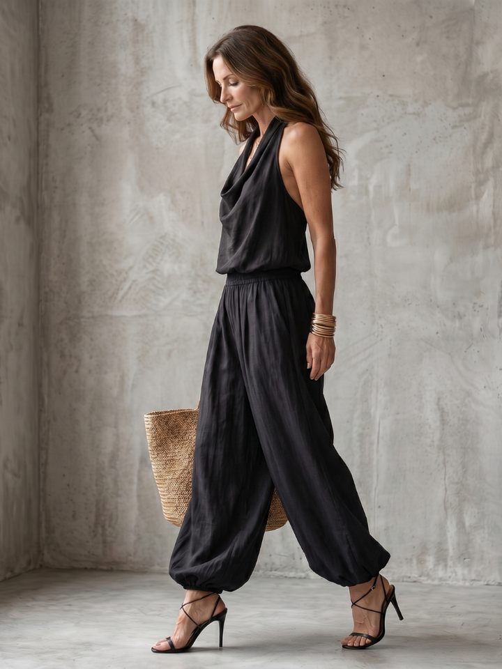Femme portant un ensemble deux pièces avec top dos-nu drapé et pantalon large, coloris noir