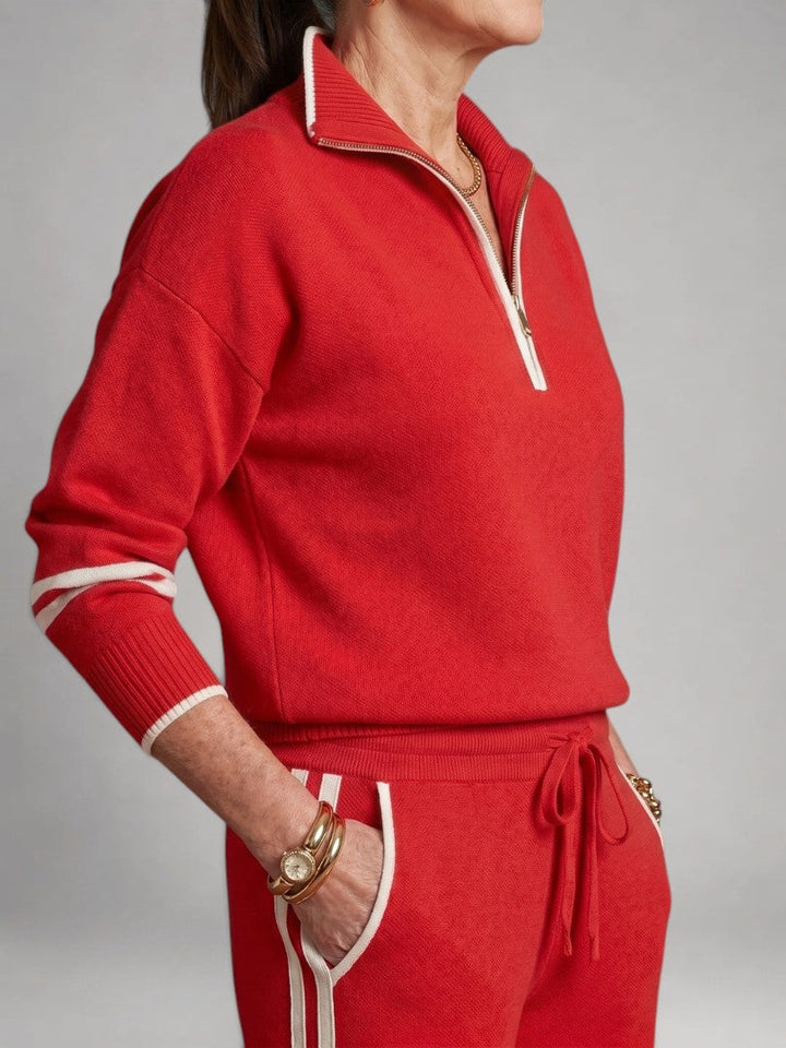 Femme portant un ensemble deux pièces en maille avec haut à col zippé et pantalon large, coloris rouge