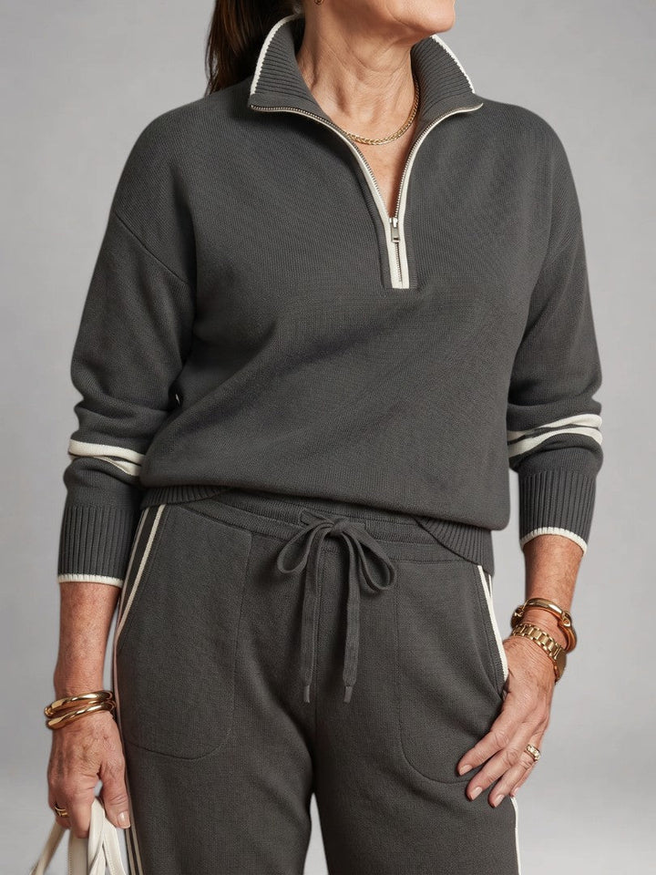 Femme portant un ensemble deux pièces en maille avec haut à col zippé et pantalon large, coloris gris