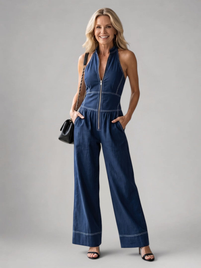 Femme portant une combinaison dos-nu à fermeture éclair devant et jambes larges, coloris bleu marine