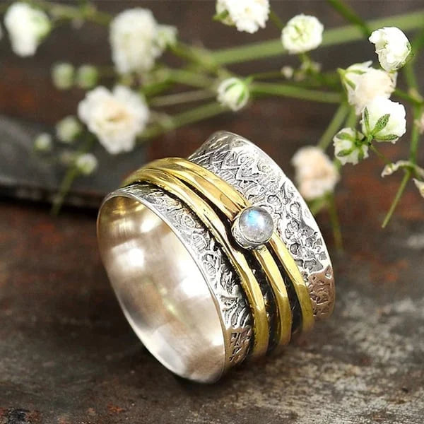 Bague tournante argentée avec bandes dorées et pierre claire