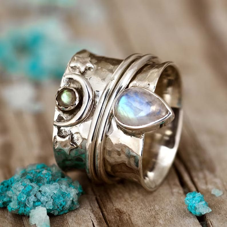 Bague tournante argentée avec une pierre claire en forme de goutte