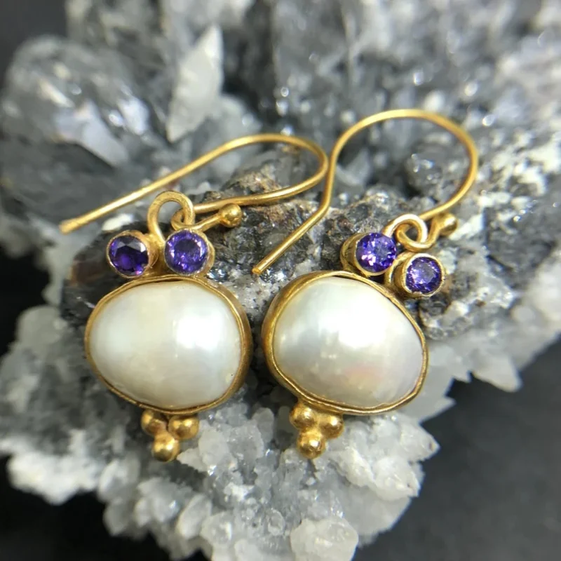 Voûte Lumineuse | Boucles d'oreilles dorées avec grand détail clair et pierre violette – Vue 01